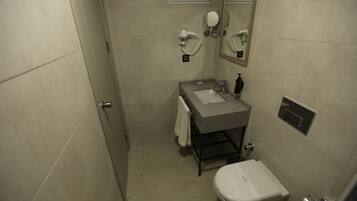 Un baño pequeño con lavamanos, espejo e inodoro.