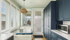 A kitchen with a built-in microwave, dark cabinets, and a window with blinds. - "BRAND NEW"  Littoral Lookout at Pacific Beach (Pacific Beach)