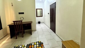 A hallway with a desk, chair, and a bed. - 1BEDROOM FLAT at UTAKO ABUJA. 24hrs LIGHT, WIFI & KITCHEN (Abuja)