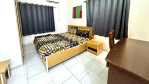 A bedroom with a wooden bed, a nightstand, a chair, and a small table. - 1BEDROOM FLAT at UTAKO ABUJA. 24hrs LIGHT, WIFI & KITCHEN (Abuja)