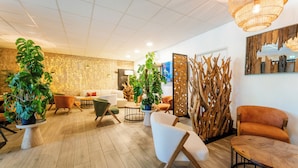 A modern lounge area with sofas, a coffee table, and potted plants. - Domaine du Vieux Porche (Mignaloux-Beauvoir)