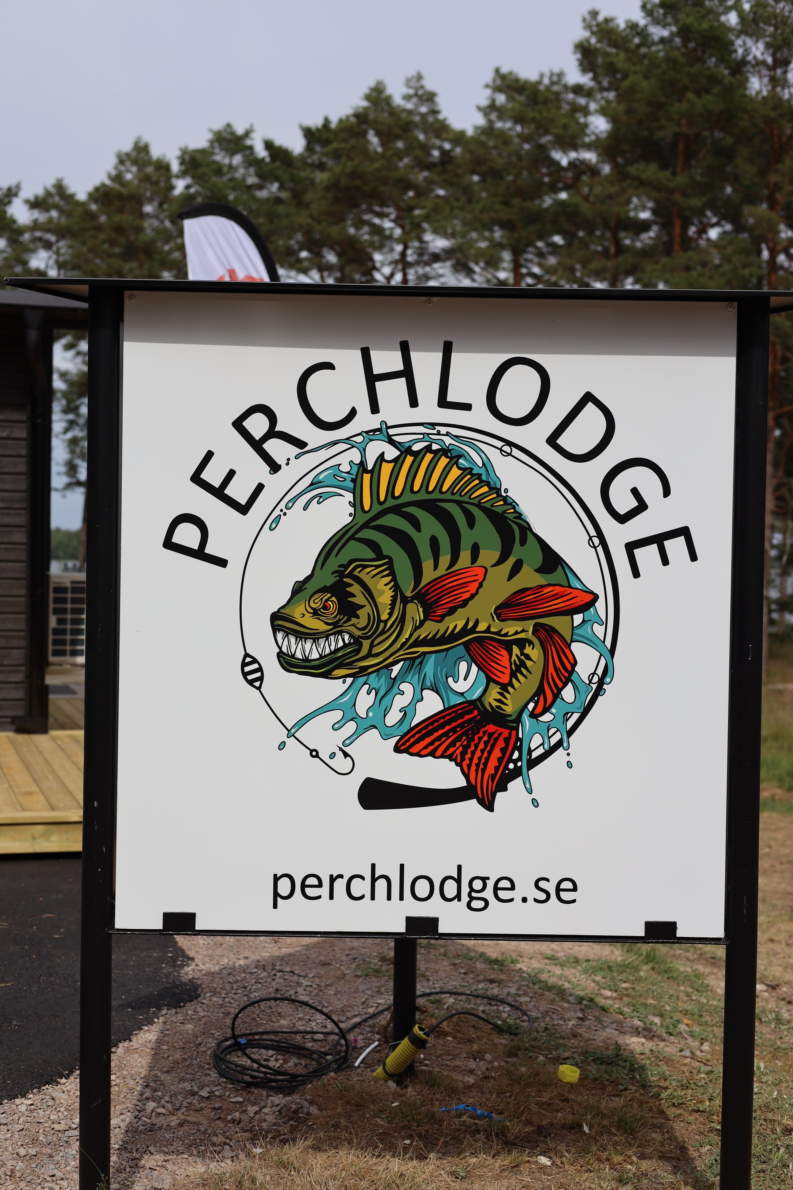 A sign with a fish illustration and the text "PERCHLODGE" and a website address.