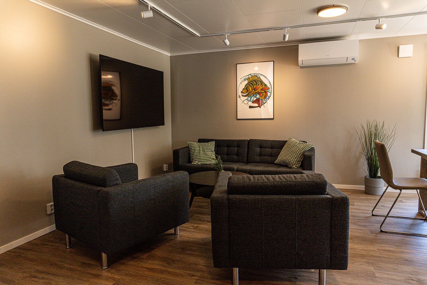 A modern living room with a sectional sofa, a flat-screen TV, and a decorative fish painting.