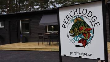 Une enseigne pour le Perch Lodge, avec une illustration de poisson et l’adresse du site web.
