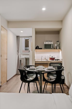 A compact hotel room with a dining area, kitchenette, and a bed. - Allende By Homirent (Queretaro)