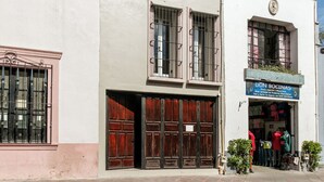 Un edificio de dos plantas con una tienda en la planta baja y un balcón en la superior.