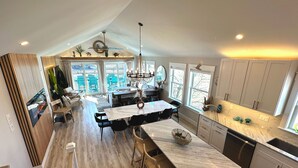 A spacious kitchen with a large island, wooden flooring, and white cabinetry. - Designer Home • 1 Block to Boardwalk & Ocean • Stunning City & Ocean Views (Atlantic City)