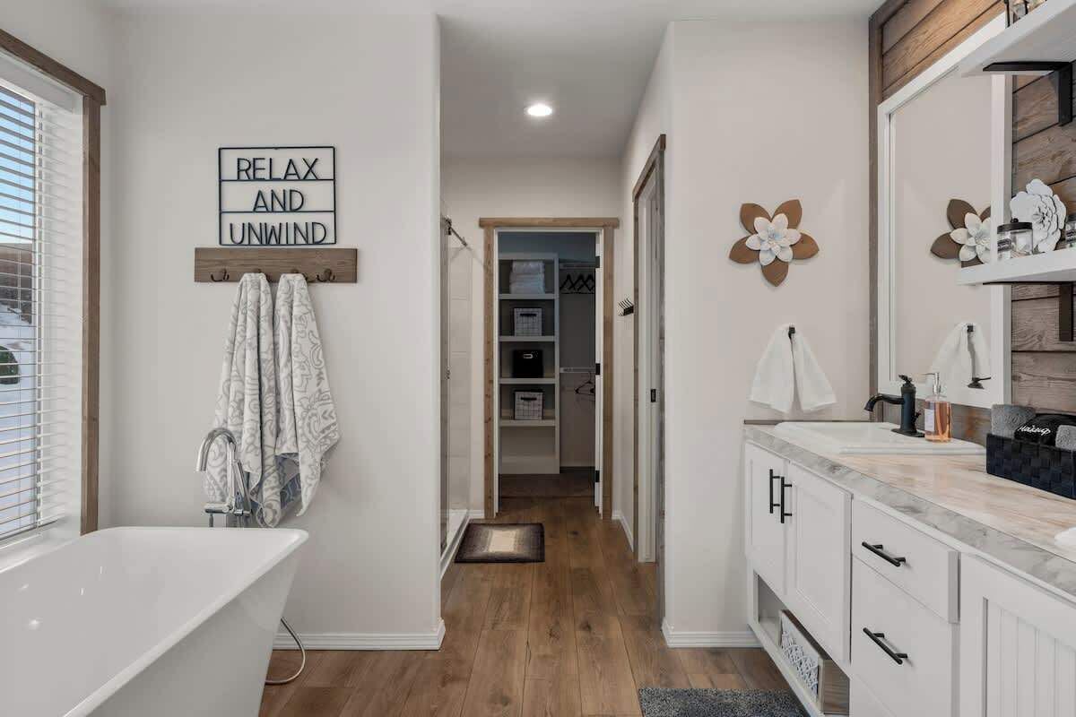 A modern bathroom with a freestanding bathtub, a vanity with a mirror, and a towel rack.