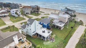 A coastal residential area with houses, a beach, and a view of the ocean.
