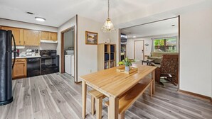 Una cucina moderna con mobili in legno, un tavolo con panche e un'ampia finestra.