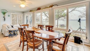 A dining area with a large table, chairs, and a ceiling fan.
