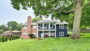 A two-story house with a large front porch, a brick chimney, and a well-maintained lawn.