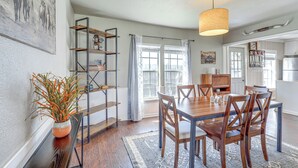 Een eetgedeelte met een houten tafel, stoelen en een hanglamp.