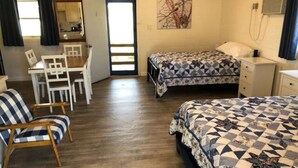 A room with two beds, a desk, and a chair. - The Lakeside Studio 6 (Bluffton)