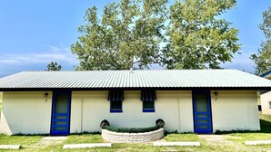 A single-story building with a corrugated metal roof, two blue doors, and a small window. - The Lakeside Studio 6 (Bluffton)