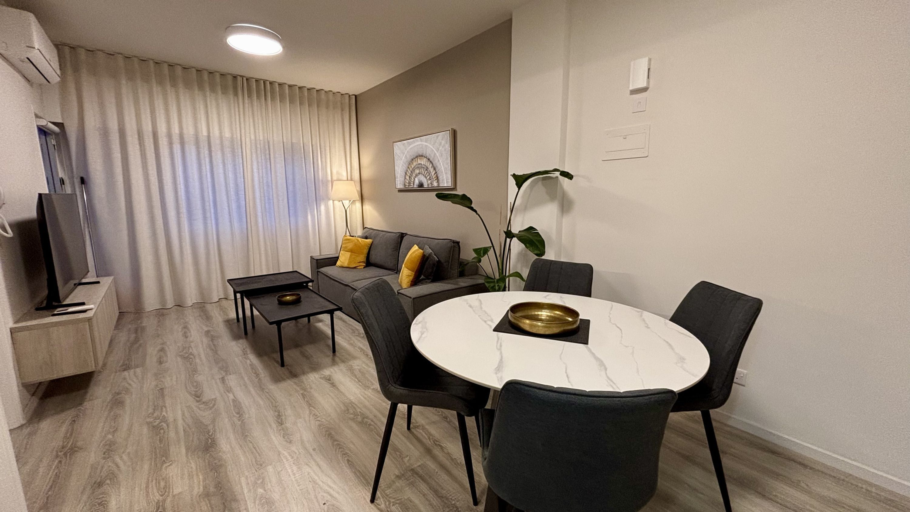 Un salon moderne comprenant un canapé, une table basse, une table à manger et des chaises.