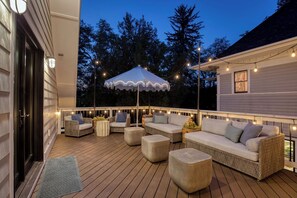 A deck with outdoor furniture, string lights, and a canopy. - Rosedale at Historic Hopffgarten House (Boise)
