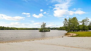 A sandy beach with a small island and trees in the distance. - Hot Tub*Arcade*Pool Table*King Bed*75" TV*Fire Pit (Pocono Summit)