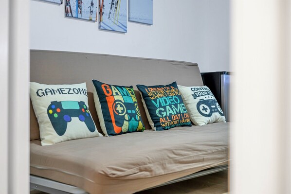 A bed with four pillows, each featuring a video game controller design. - Hot Tub*Arcade*Pool Table*King Bed*75" TV*Fire Pit (Pocono Summit)