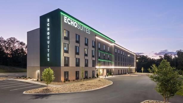 A modern hotel building with the name 'Echosuites' prominently displayed. It features a rectangular structure with multiple windows and a well-lit entrance. - Echo Suites Extended Stay By Wyndham Johnson City Medical Cr (Johnson City)