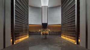 A modern lobby with a central column, dark walls, and a patterned floor. - Wyndham Grand Chengdu East (Chengdu)