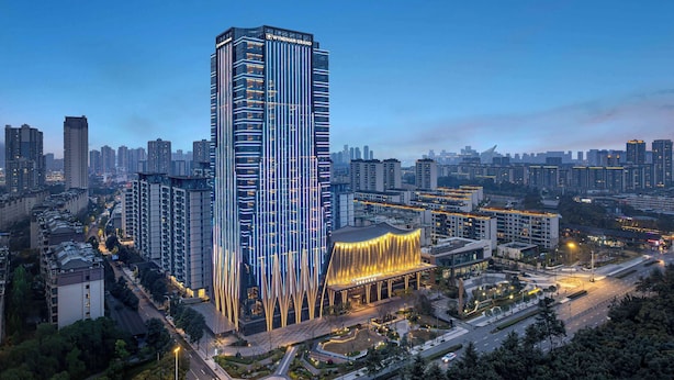 A high-rise building with a modern design, surrounded by other high-rise buildings in an urban setting. - Wyndham Grand Chengdu East (Chengdu)