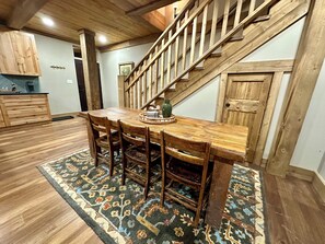 Enjoy meals in the dining area with a wooden table and six chairs, surrounded by a patterned rug.