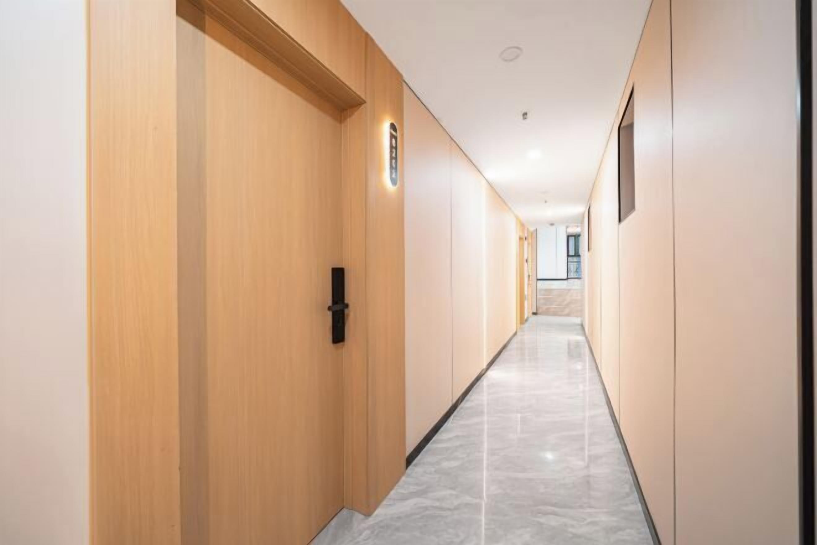 A long, narrow hallway with wooden walls and a marble floor.