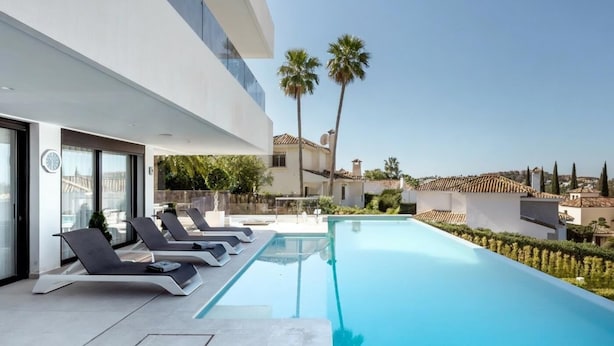 A modern poolside area with lounge chairs, a clear pool, and a view of the surrounding landscape. - Luxury Villa with Views Marbella  (Marbella)