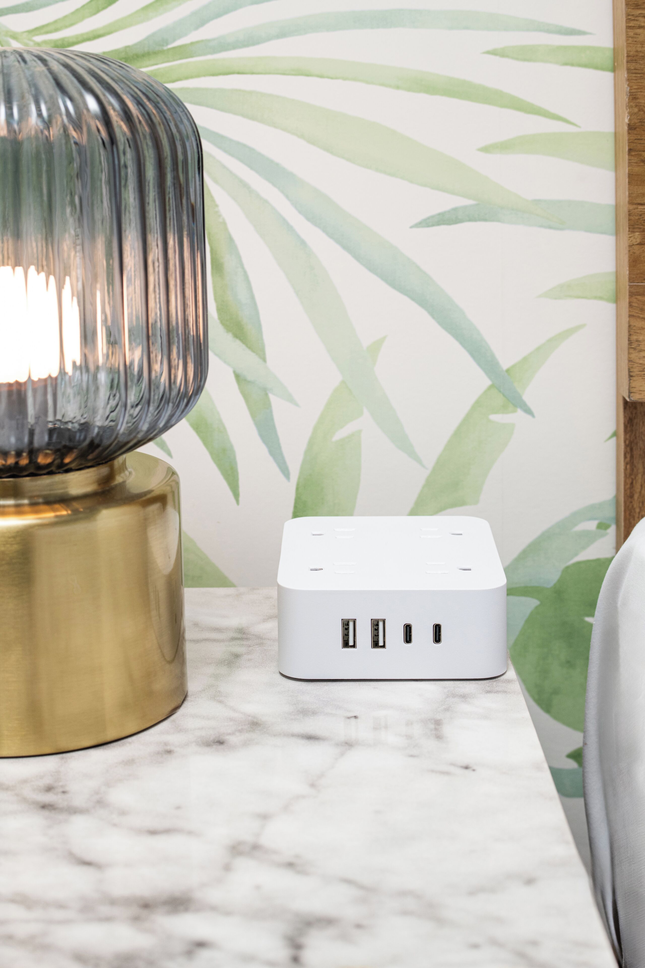 Un appareil électronique blanc doté de plusieurs ports USB, posé sur une surface en marbre.