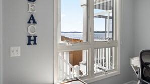 A room with a large window overlooking a snowy landscape, a white desk, and a wall-mounted light switch. - Bayfront Coastal Paradise | Pool | Beach Access (Bethany Beach)
