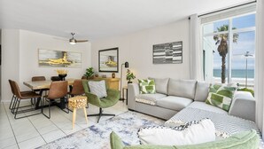 Ein modernes Wohnzimmer mit Essbereich, einer Sofagarnitur und Meerblick.