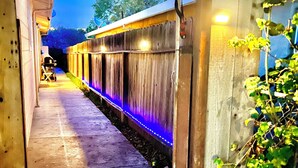 Andén de estación de tren con una valla de madera y un camino de hormigón.
