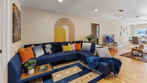 Una sala de estar moderna con un sofá modular, una mesa de centro y un televisor.