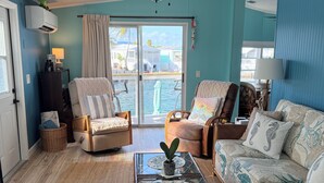 A living room with a glass coffee table, two armchairs, a sofa, and a ceiling fan. - Canal front with open water views in Venture Out - Lot 529 (Cudjoe Key)