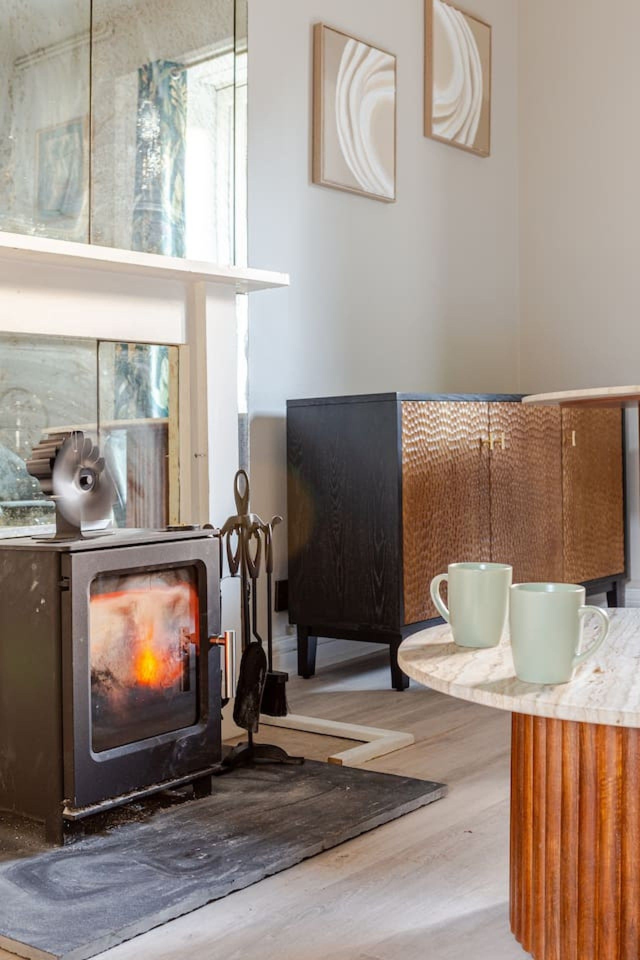 A kitchen with a wood-burning stove, a cabinet, and a window.