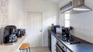 Eine kleine Küche mit Gasherd, Toaster und Kaffeemaschine.
