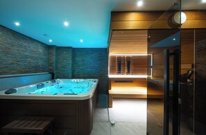 Un moderno spa con hidromasaje, paneles de madera y una separación de vidrio.