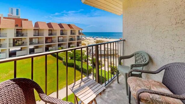 Un balcone con vista sulla spiaggia e sugli edifici dell'hotel.
