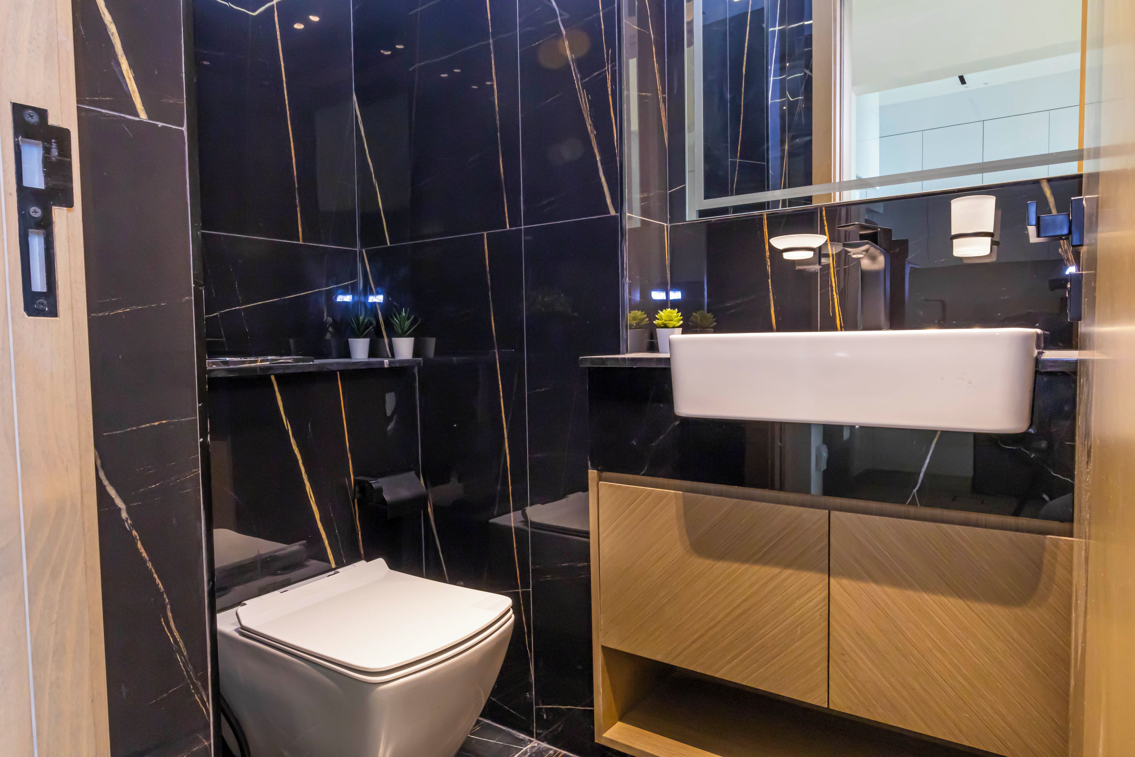 A modern bathroom with a toilet, vanity, and a mirror.