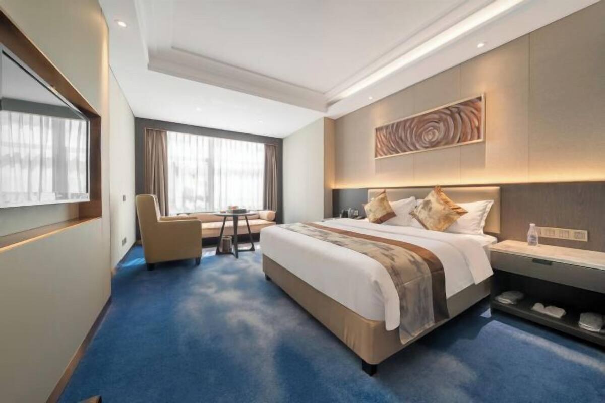 Una habitación de hotel con una cama grande, un escritorio y una silla.