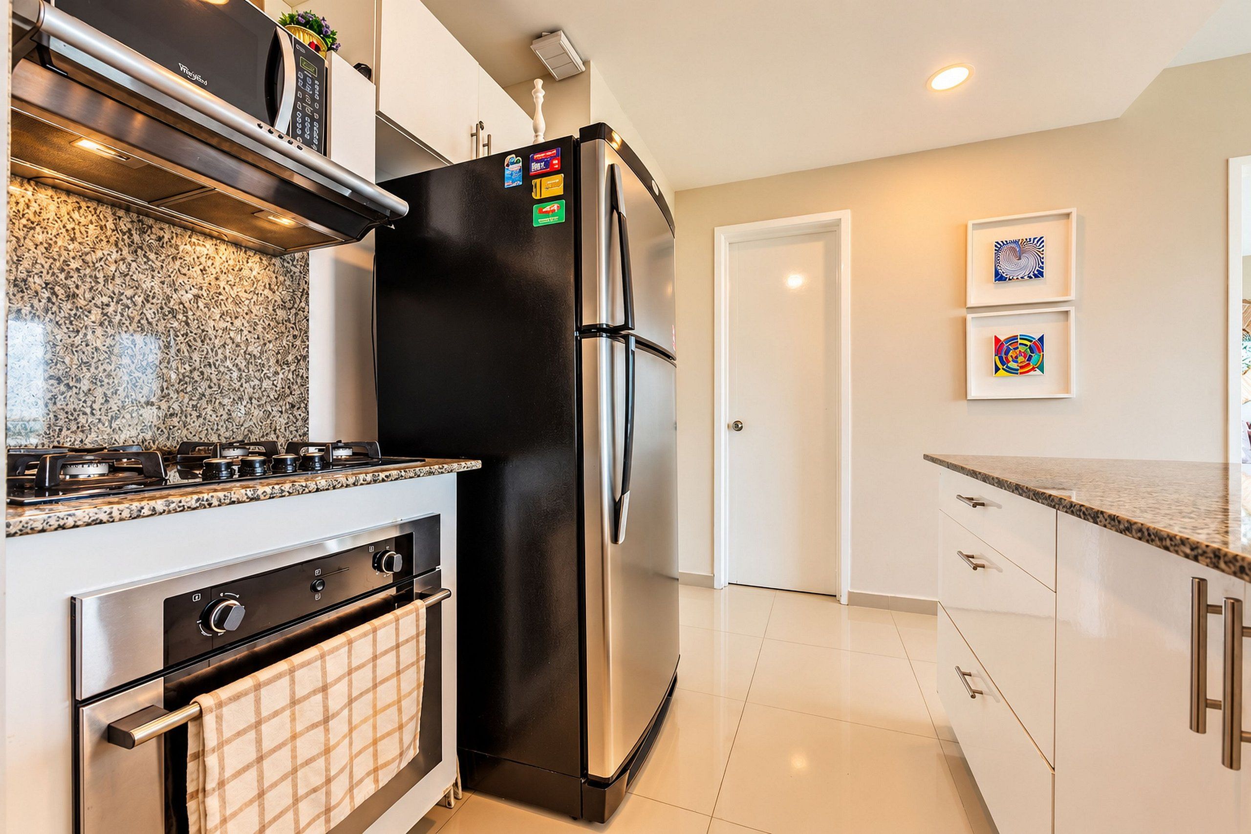 Una cocina moderna con refrigerador, horno y estufa de acero inoxidable.