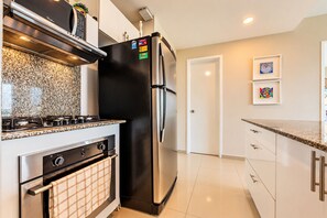 A modern kitchen with a stainless steel refrigerator, oven, and stove. - Condominio frente al mar  Morros Epic. (Cartagena)