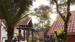 A courtyard with a wooden pergola, benches, and a pathway. - Pousada Sol Nascente (Camanducaia)