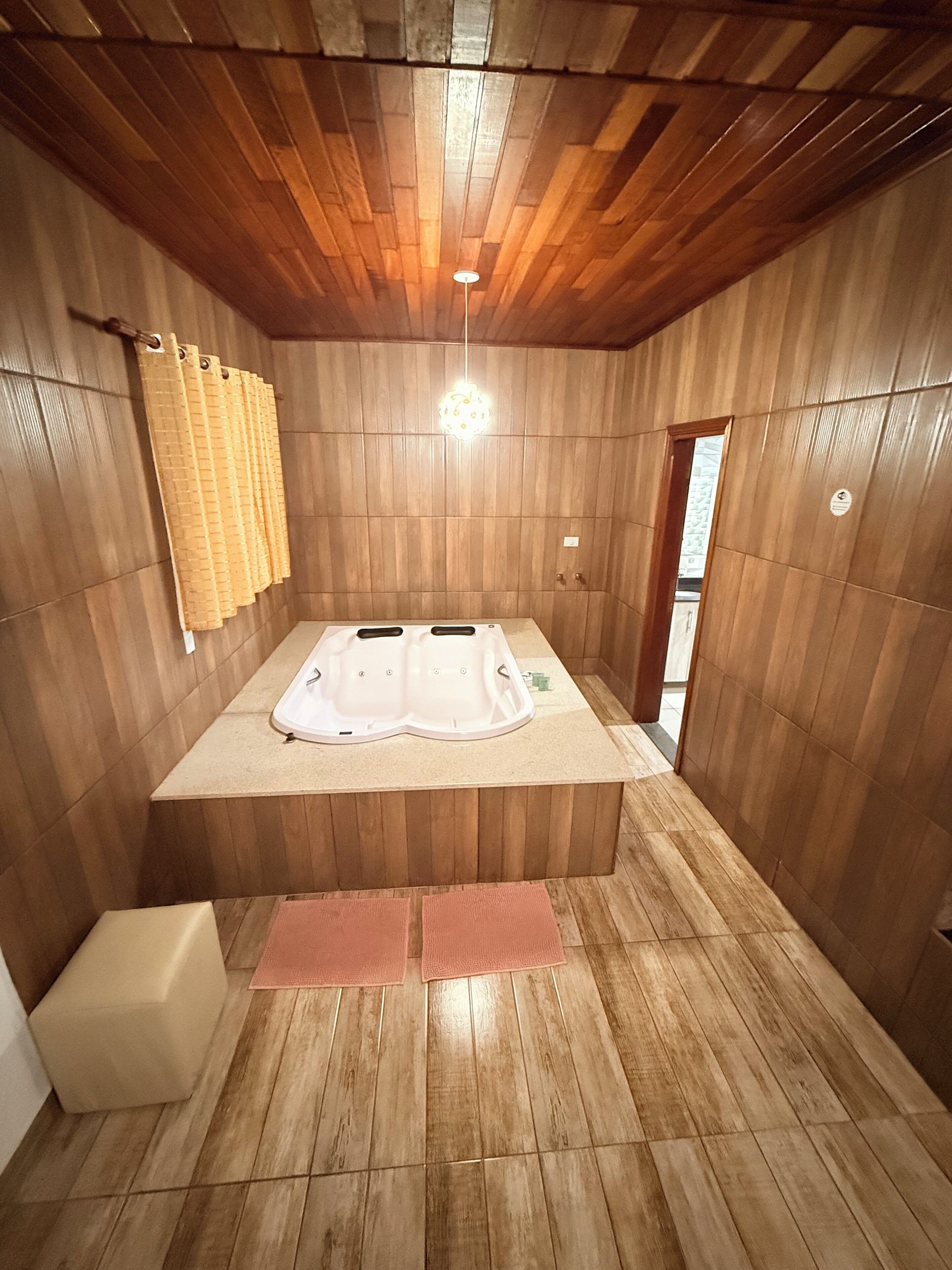 A wooden room with a sauna, a bench, and a towel rack.