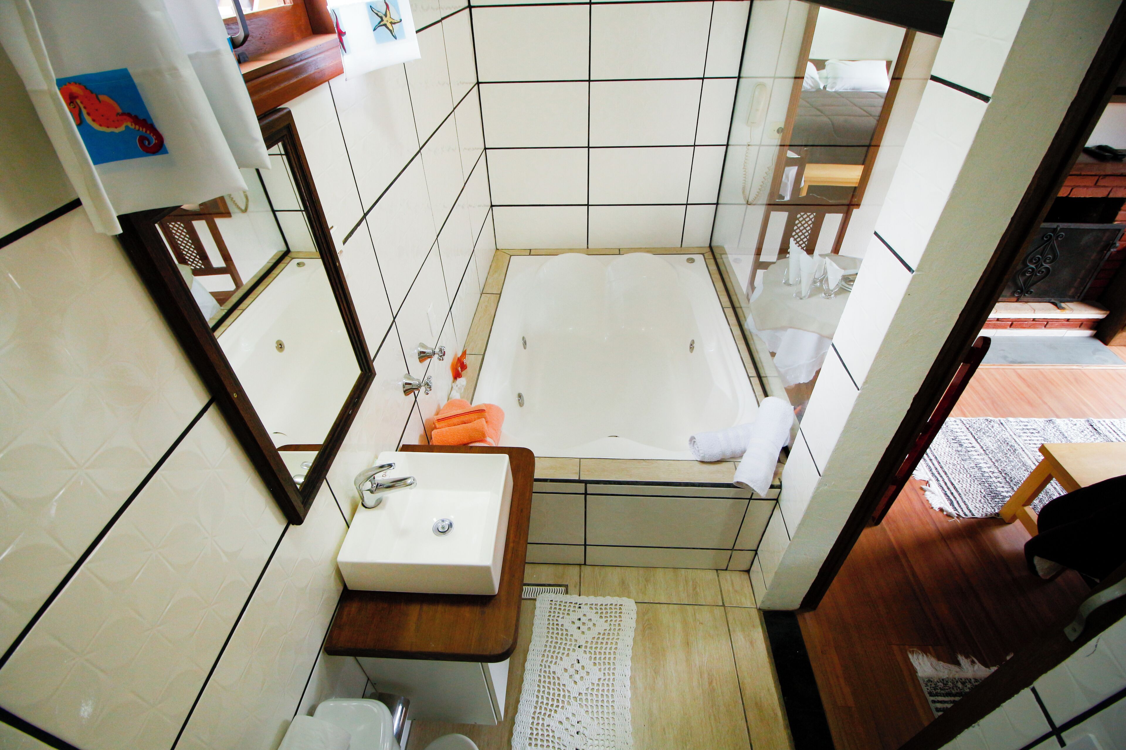 Un baño pequeño con bañera, lavamanos y espejo.