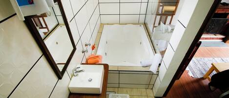 Un baño pequeño con bañera, lavamanos y espejo.
