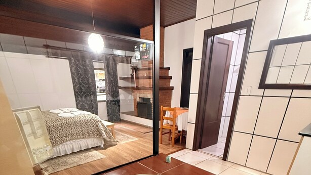 A modern bathroom with a large bathtub, wooden flooring, and a visible shower area. - Pousada Sol Nascente (Camanducaia)