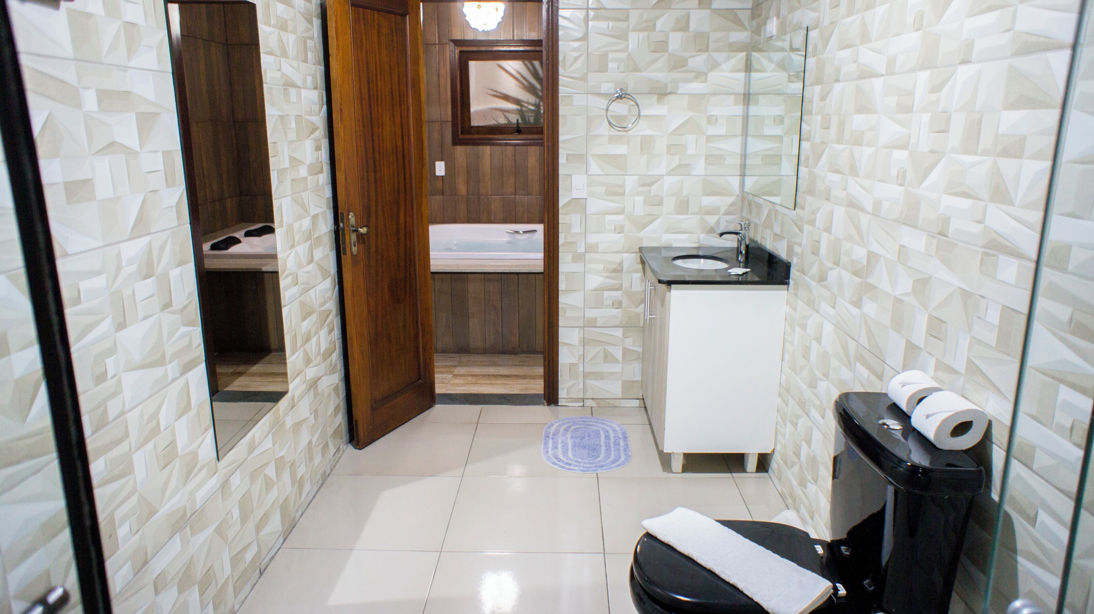 Un baño pequeño con inodoro, lavamanos y zona de ducha.