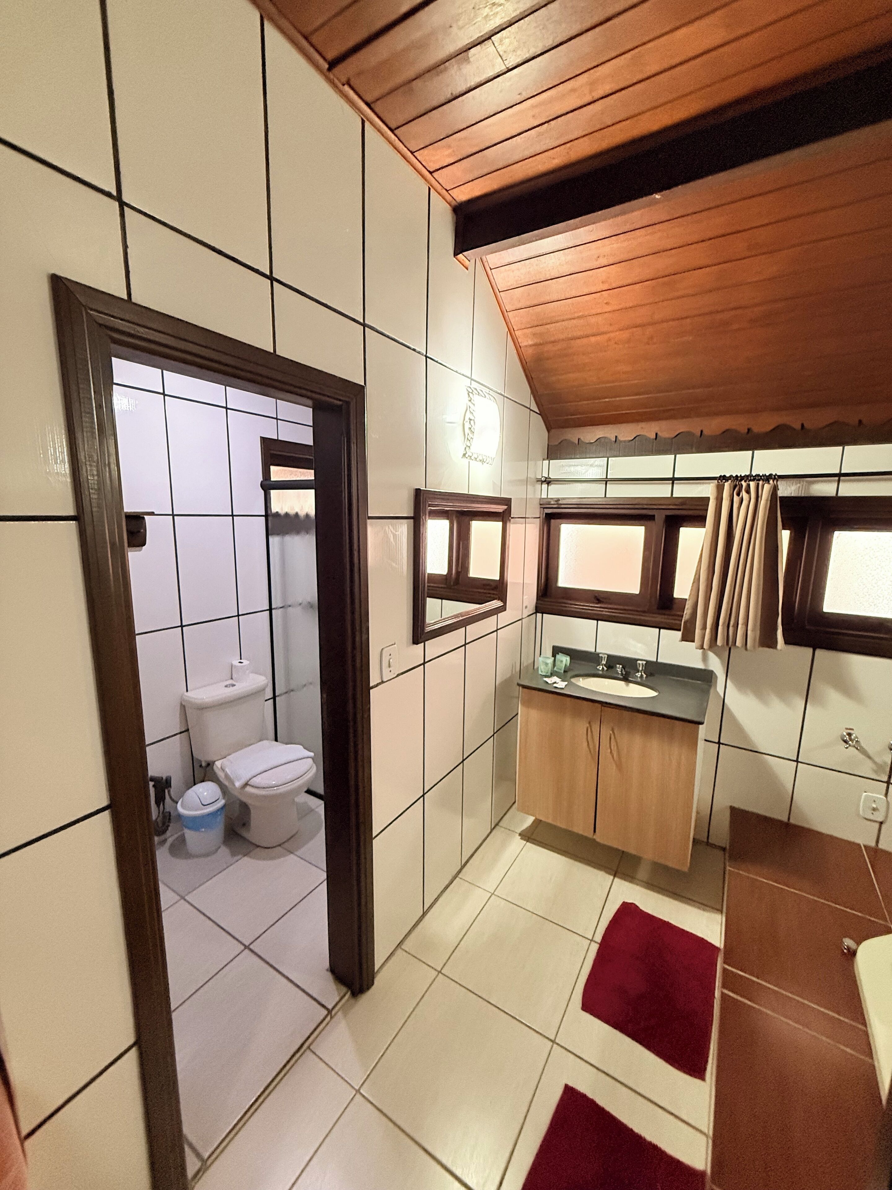 A compact bathroom with a toilet, sink, and mirror.